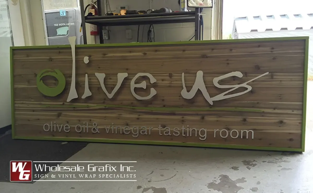 Olive Us oil and vinegar tasting room sign on wood