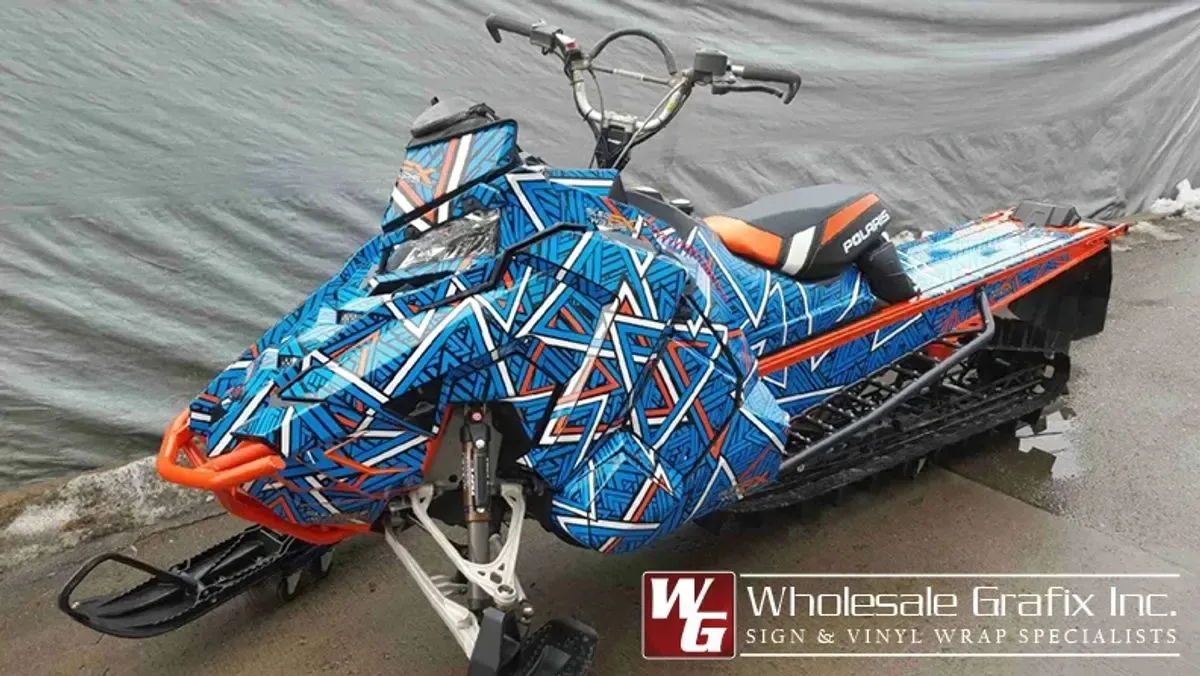 Snowmobile in a blue and orange geometric shatter wrap