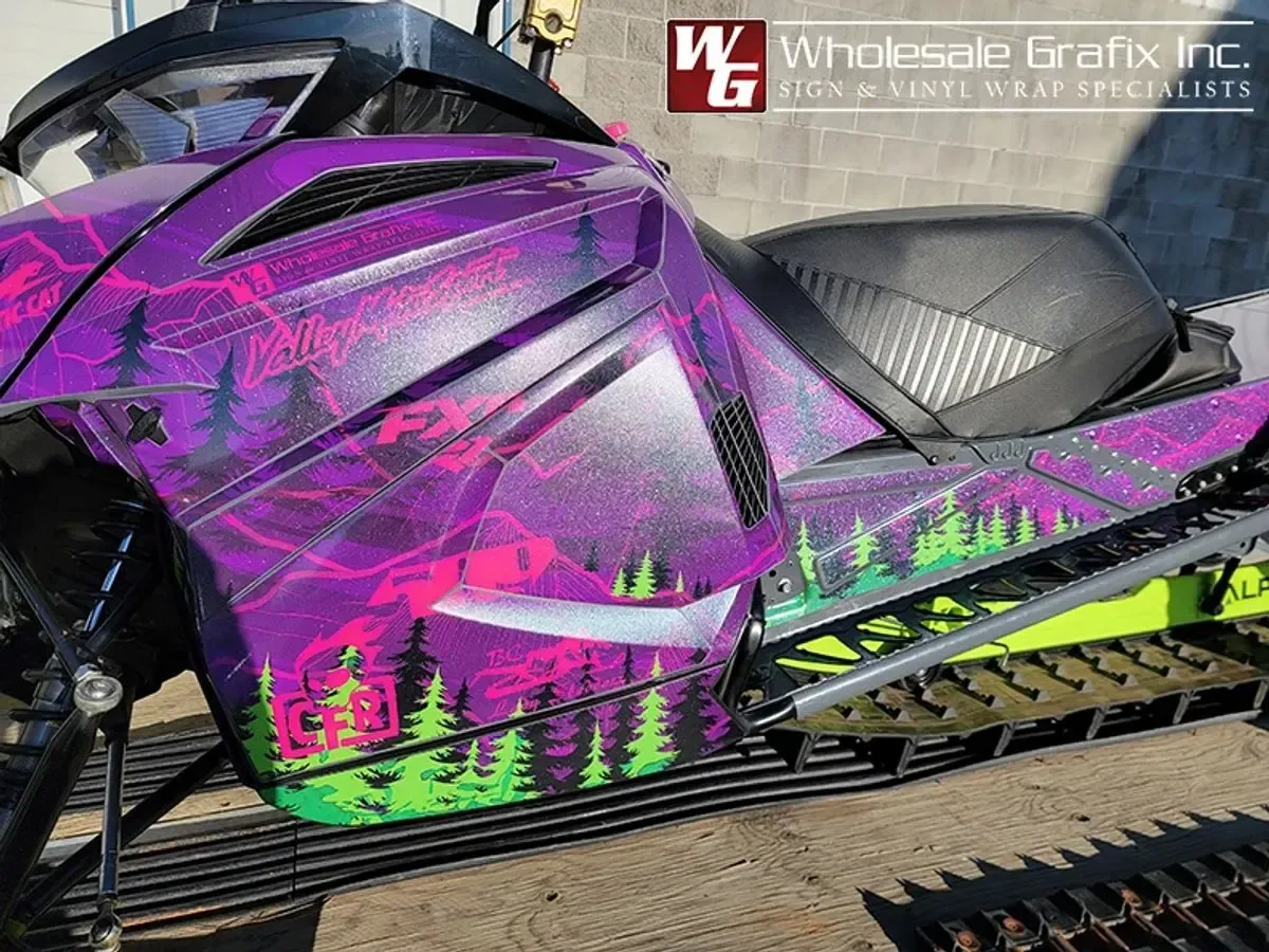 Snowmobile wrapped in a custom northern lights art design by Wholesale Grafix