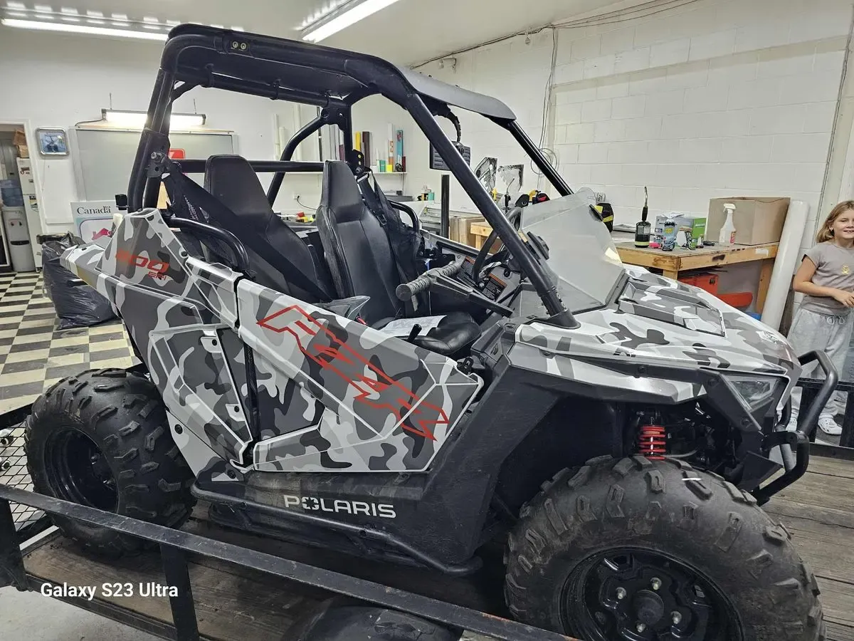Polaris RZR side-by-side in a white and grey camouflage wrap