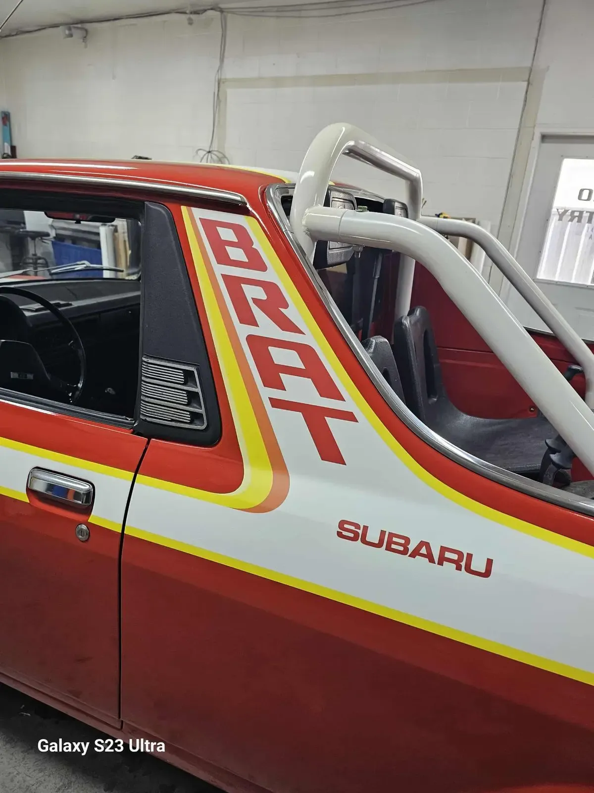 Red and yellow Subaru BRAT with retro stripe graphics